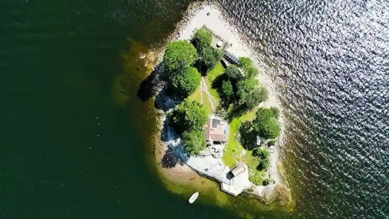 island in the sea with green trees and solar panels